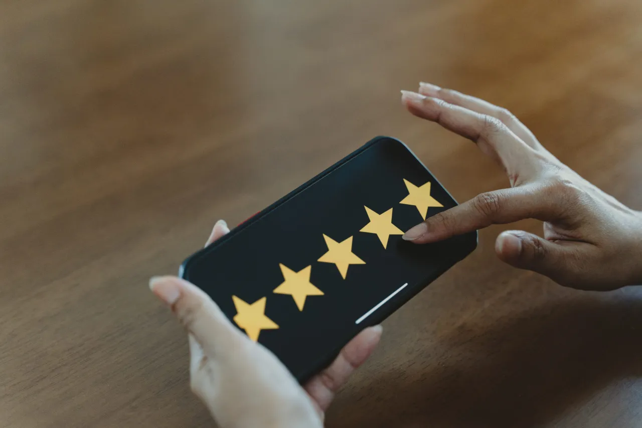 A hand pressing a five-star customer rating.